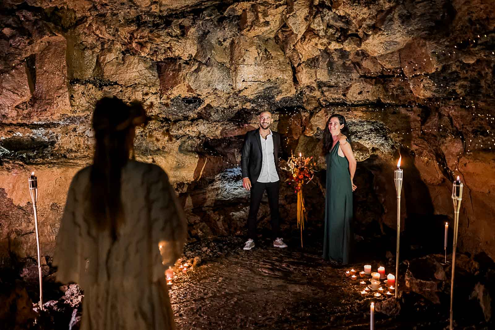 Photographie de Mathieu Dété, photographe de mariage sur l'île de la Réunion à Saint-Pierre, présentant l'entrée dans la cérémonie de la mariée, dans le tunnel de lave du Bassin Bleu, lors d'un shooting inspiration mariage