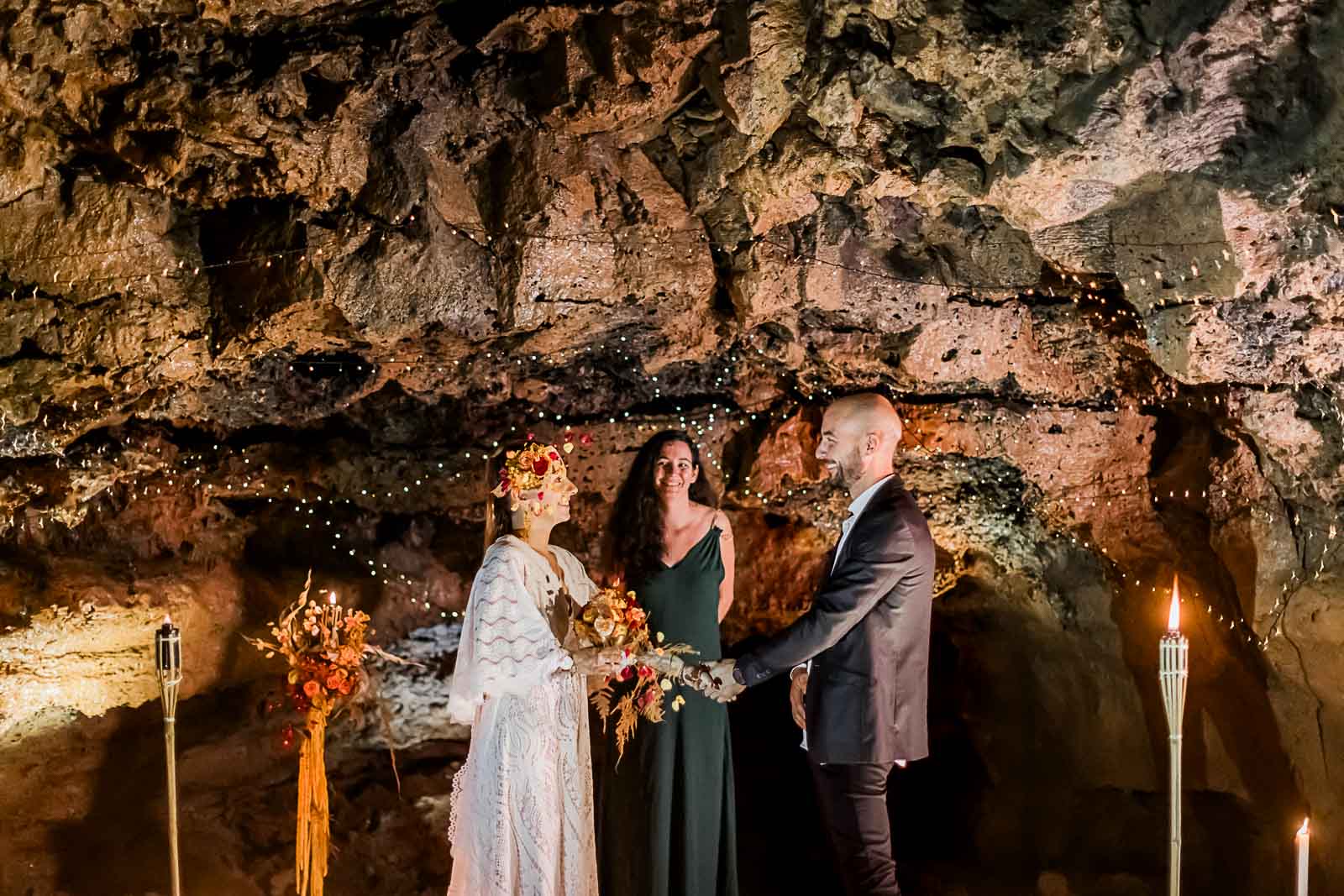 Photographie de Mathieu Dété, photographe de mariage sur l'île de la Réunion à Saint-Pierre, présentant la cérémonie d'un elopement avec l'officiante au sein d'un tunnel de lave à Saint-Gilles, lors d'un shooting inspiration mariage