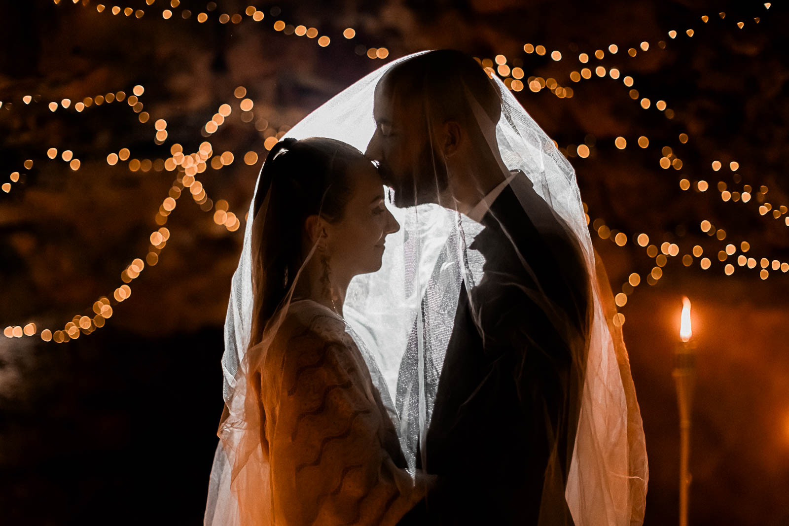 Photographie de Mathieu Dété, photographe de mariage sur l'île de la Réunion à Saint-Pierre, présentant les mariés sous le voile lors d'un elopement dans le tunnel de lave du Bassin Bleu