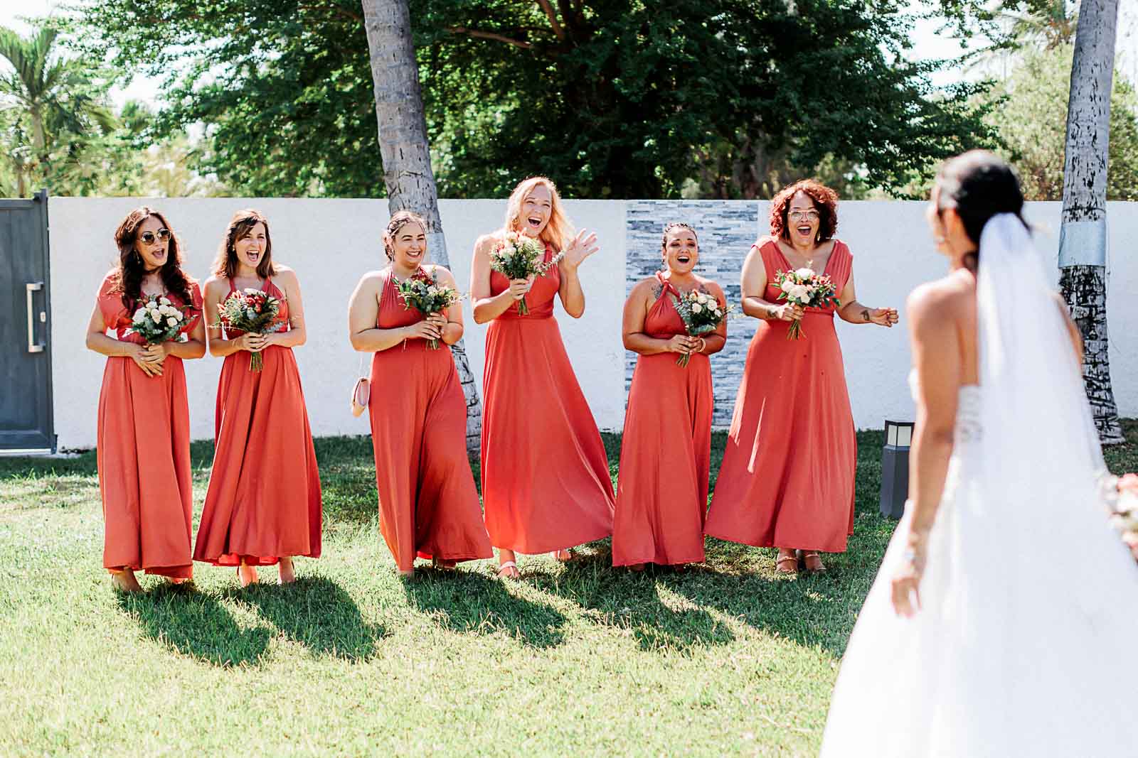 Photographie de Mathieu Dété, photographe de mariage et famille à Saint-Pierre sur l'île de la Réunion 974, présentant la mariée avec ses demoiselles d'honneur, lors de la découverte de la robe