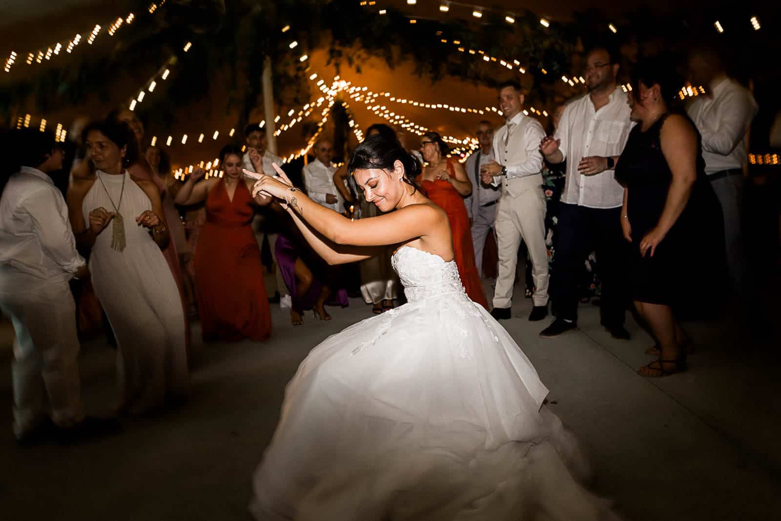 Photographie de Mathieu Dété, photographe de mariage et famille à Saint-Gilles sur l'île de la Réunion 974, présentant la mariée qui danse sur la piste de danse lors de la soirée du mariage au Jardin d'Eden