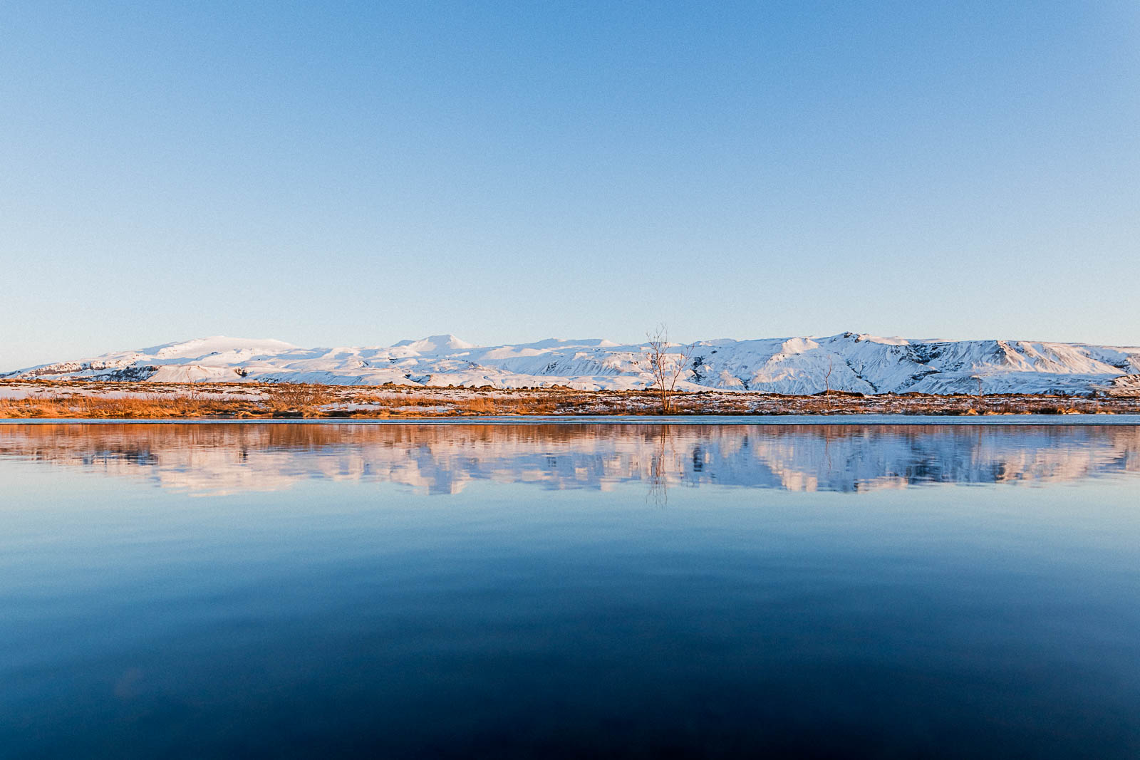 Photographie de Mathieu Dété, photographe de mariage et de voyage à la Réunion, présentant une photo de reflets de montagnes enneigées, lors d'un voyage en Islande